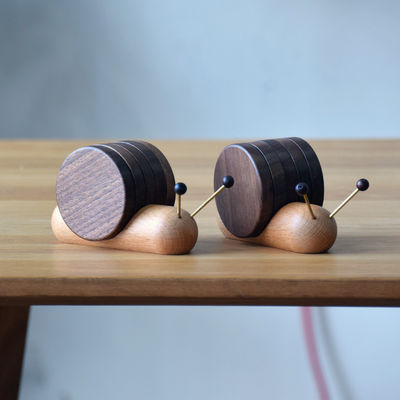 Des chaussettes à roulettes noires créatives en forme d'escargot, une tasse isolante en bois, une soucoupe de style moderne.